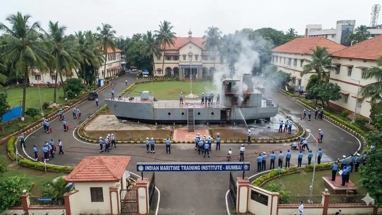 GP Rating Course क्या है? (2026) Fees, Eligibility, Salary | Merchant Navy 2 Indian maritime training institute campus view with students in uniform performing a fire fighting drill on a ship-in-campus model.